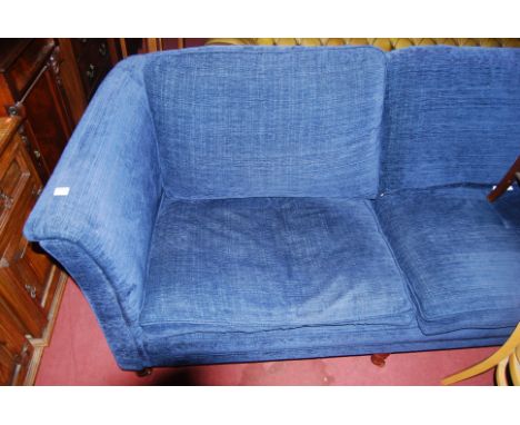 A contemporary blue fabric upholstered three seater sofa, raised on turned forelegs to brass cap castors, width 197cm.Approx 