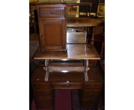 An Ercol dark elm kneehole mirrorback dressing table, together with a further matching single bedside cupboard, and an oak lo