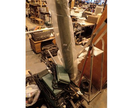 Quantity of garden items and tools in a folding wheel barrow and plastic plant holder and large parasol with a light on the t