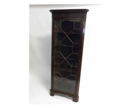 Early 20th century mahogany floor-standing corner cupboard with single astragal glazed door, fretwork style carved frieze fit