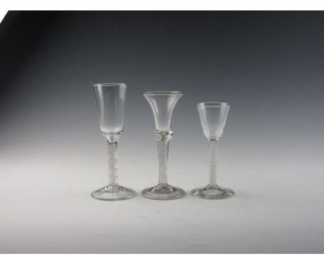 Three Georgian Wine Glasses, comprising an air twist with trumpet bowl and folded foot; a double serie opaque with conical bo