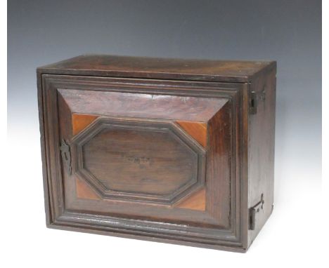 An 18th Century oak Spice Cupboard with single hinged and panelled door enclosing multi drawers with ring handles, 15 3/4in W