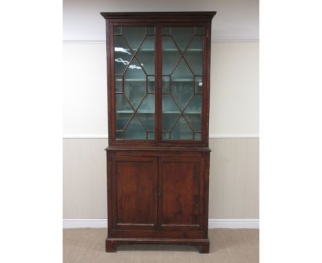 A Georgian stained pine Cabinet with pair of astragal glazed doors above pair of solid panelled doors on bracket feet, 3ft 3i