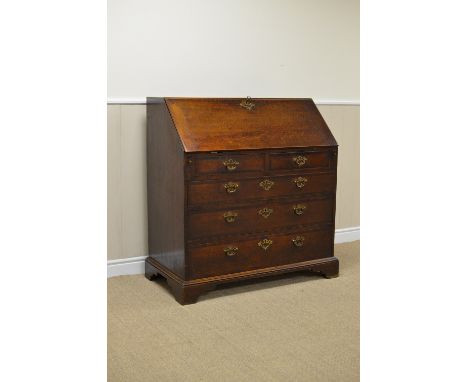 An 18th Century oak Bureau, the well fitted interior with mirrored door, small drawers, secret drawers, pigeon holes, etc, tw