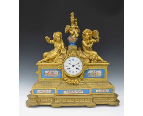 A large French gilt metal Mantel Clock with porcelain vase surmount flanked by cherubs playing musical instruments with porce