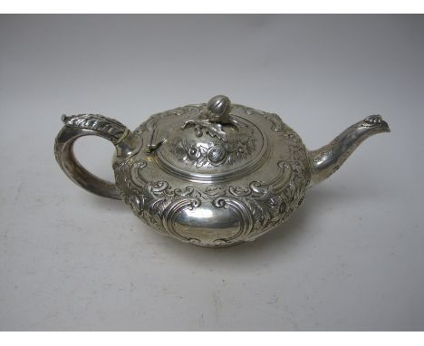 A Victorian silver Teapot of compressed circular form with floral and scroll embossing, fruit finial, London 1877, maker: W.S