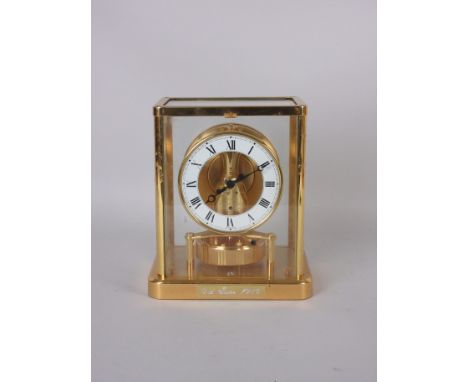 A Jaeger LeCoultre Atmos Clock with gilt case, the chapter ring marked with Roman numerals above the rotating pendulum, 9in H