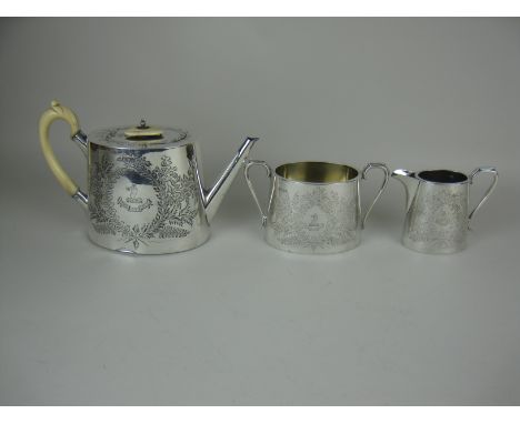 A Victorian silver three piece oval Tea Service with presentation inscription, crest, motto and leafage engraving, Sheffield 