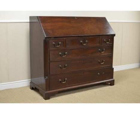 A George III mahogany Bureau with well fitted interior above three short and three long drawers flanked by quarter round pila