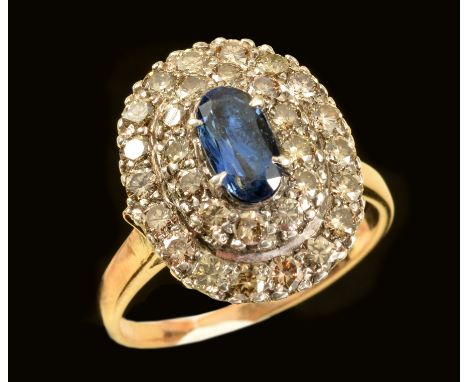 A Sapphire and Diamond Cluster Ring claw-set oval-cut sapphire within double frame of brilliant-cut diamonds, ring size R