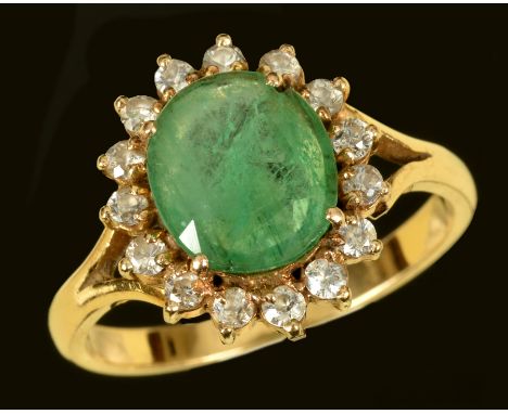 An Emerald and Diamond Cluster Ring claw-set oval-cut emerald within frame of fifteen brilliant-cut diamonds, stamped 18ct, r