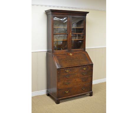 An antique oak Bureau Bookcase with pair of plain glazed doors above small drawers and pigeon holes, four long graduated draw