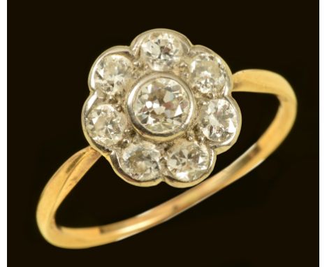 A Diamond Cluster Ring rub-over set old-cut stone within seven smaller stones