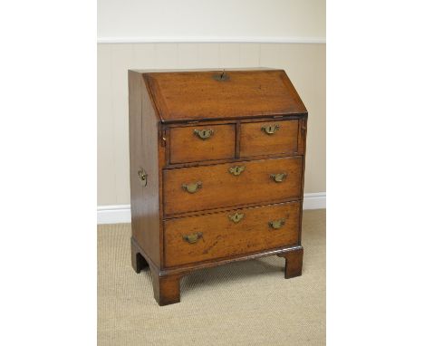 An early 18th Century small oak Bureau with interior drawers and pigeon holes over two short and two long drawers on bracket 