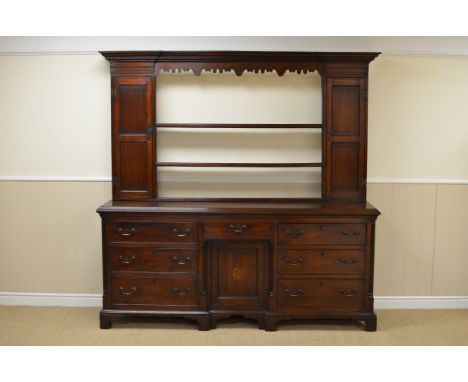 A Georgian mahogany Lancashire Dresser and Rack, the shelves with dentil frieze above shaped apron and open shelves flanked b