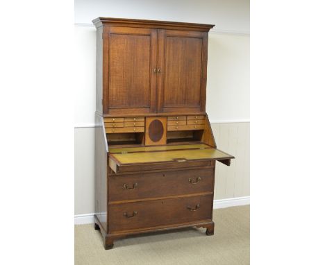 An 18th Century oak Bureau Cabinet with pair of solid panelled doors above fitted interior having central door, numerous smal