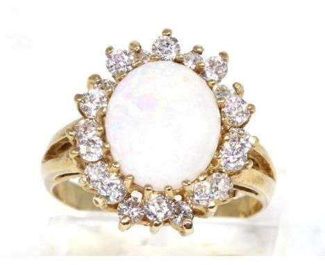 A 9 carat gold opal and cubic zirconia cluster ring, an oval cabochon opal in a claw setting, within a two tier border of rou