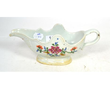 A Chinese porcelain sauce boat, Qianlong, of silver shape with strap handle, painted in famille rose enamels with flowerspray