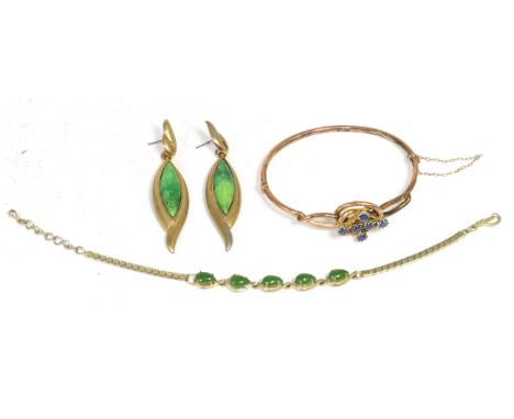 A sapphire bangle, a cluster of round cut sapphires in claw settings, within a chased knot frame, on a plain hinged bangle, m