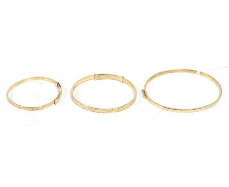 A 9 carat gold hinge opening bangle, with engraved star motif, measures 6cm by 5.5cm and two 9 carat gold foliate engraved in