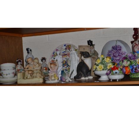 A shelf of ceramic including; a Karl Enz figure of a baby, a masons vase, Kaiser vase, floral encrusted wares including Crown