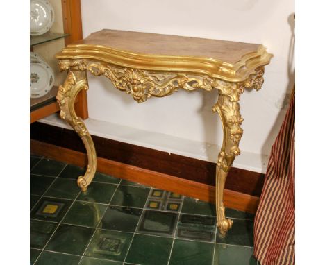 Gilded wood console Italy, 20th centuryshaped top resting on supports carved with plant and floral motifs88x100x46 cm.