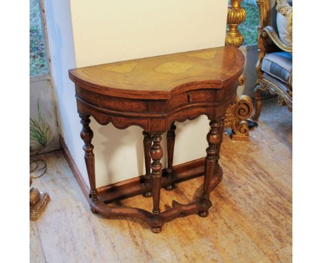 Walnut game table Italy, 20th centuryopening top partially covered in fabric resting on turned cross-jointed supports77x82x35