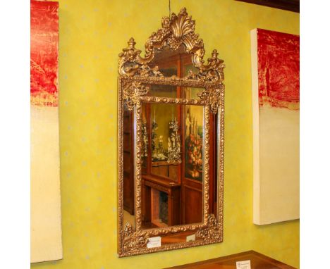 Gilded wood mirror Italy, 20th centuryRectangular frame carved with floral and plant motifs146x72 cm.