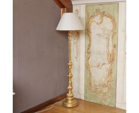 Gilded wood floor lamp Italy, 20th centuryturned and podded body, complete with lampshadeh. 185 cm.