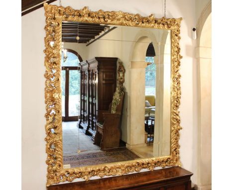 Large gilded wood mirror Italy, 20th centuryrectangular frame richly carved with plant motifs220x190 cm.