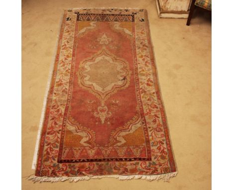 Oriental carpet 20th centurydecorated with plant and floral patterns on an orange background, wears and defects195x100 cm.