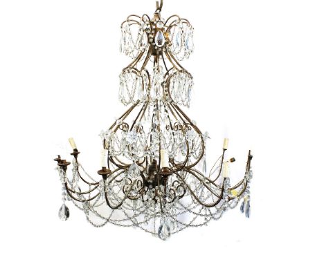 Twelve lights iron chandelier Italy, 20th centuryshaped line structure with opposite volutes decorated with pending elements 