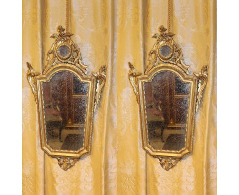 Pair of gilded wooden mirrors Italy, XVIII century.structures carved with scrolls and plant motifs, slight defects73x40 cm.
