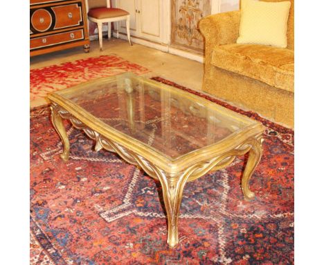 Golden wood coffee table Italy, 20th centuryshaped glass top resting on a wooden base carved with intertwined scrolls and pla