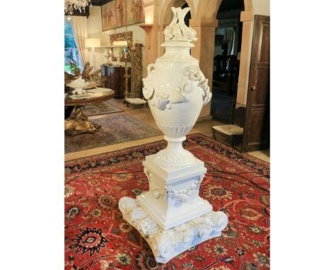 Large white ceramic vase Italy, 20th centurydecorated with shells and mythological animals, resting on a white lacquered wood