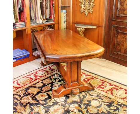 Walnut-stained wood table Italy, 20th centurytop with openable flaps resting on two architectural supports gathered at the ce