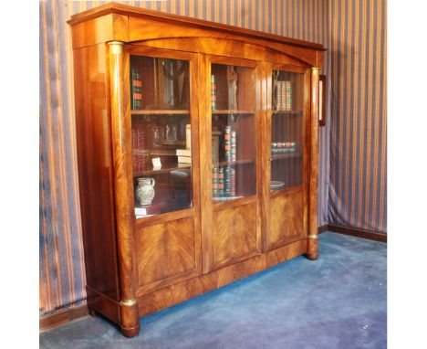 Mahogany and mahogany feather bookcase Italy, 20th centuryfront with three doors delimited by turned columns with bases and c