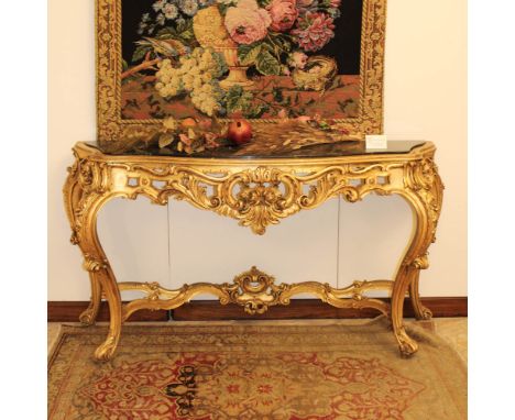 Golden wood console Italy, 20th centurycarved with floral, plant and scroll motifs, shaped top in green marble90x177x53 cm.