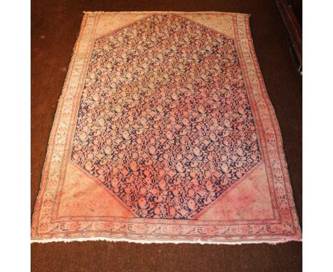 Oriental carpet 20th centurydecorated with plant patterns on an orange and blue background, wears and defects185x126 cm.