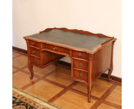 Walnut bureau desk Italy, 19th centuryshaped top partially covered in leather delimited by wooden railing, with seven drawers
