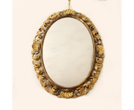 Gilded wood mirror Italy, 20th centuryoval frame carved with volutes and shells110x77 cm.