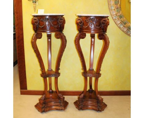 Pair of tripod bases Italy, 20th centurystructures carved with rams' heads and plant garlands, shaped tops in white Carrara m