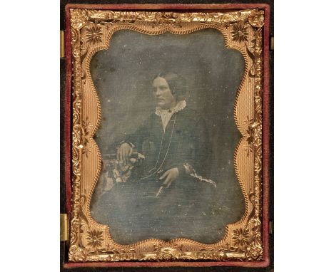 * Daguerreotypes. A one-quarter plate daguerreotype of a seated young woman holding a book, circa 1860, some marginal spottin