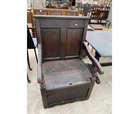 A GEORGIAN OAK COMMODE CHAIR WITH PANELLED BACK, SHAPED ARMS AND LIFT-UP SEAT 