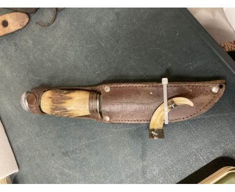A VINTAGE HUNTING KNIFE WITH HORN HANDLE IN A LEATHER SHEATH 