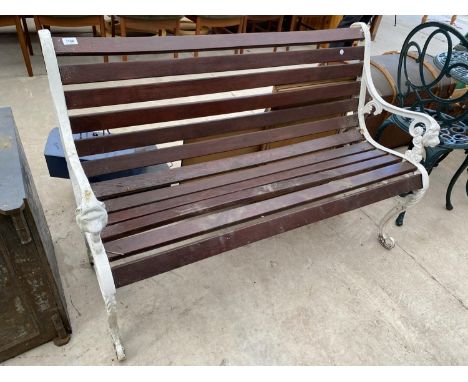 A WOODEN SLATTED GARDEN BENCH WITH CAST BENCH ENDS 