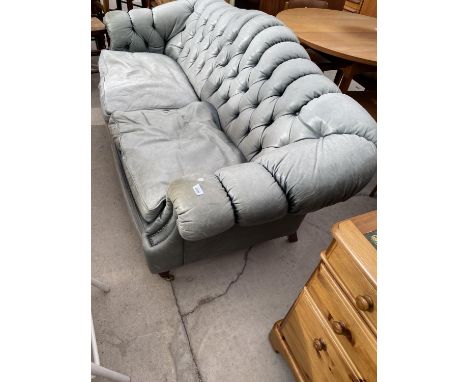 A GREEN VICTORIAN STYLE SOFA WITH CHESTERFIELD BACK AND TURNED FRONT LEGS WITH CASTERS 