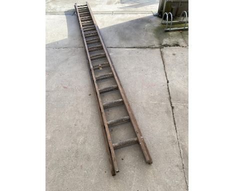 A VINTAGE WOODEN TWO SECTION 32 RUNG EXTENDABLE LADDER 