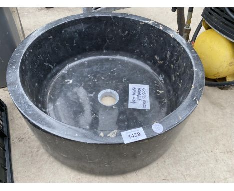 A SOLID BLACK MARBLE WASH BASIN 
