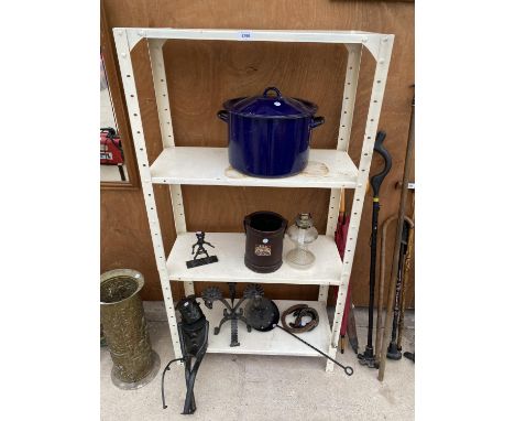 A FOUR TIER METAL SHELVING UNIT WITH CONTENTS TO INCLUDE A COOKING POT, HORSE SHOES AND AN OIL LAMP ETC 